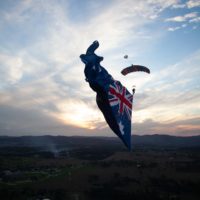 Skydiver under canopy with a flying flag