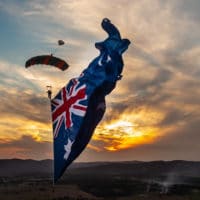 Skydiver under canopy with a flying flag