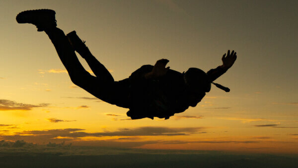 Skydiver silhouette at sunset during skydiving expedition Tim Parrant extreme skydiving