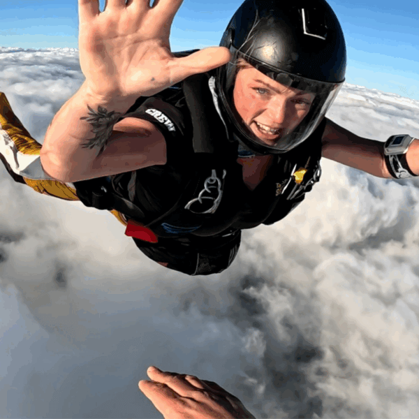 Sophie skydiving in freefall above the clouds during a jump.