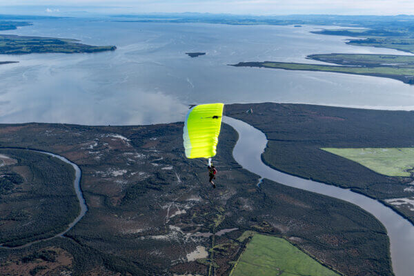 Safire 4 canopy flying above Lake Taupō and surrounding landscape.