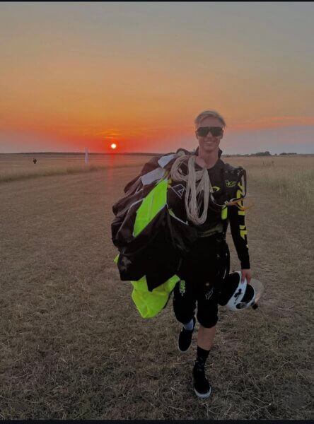 JYRO athlete Máté Feith carrying his Safire 4 canopy after landing at sunset.