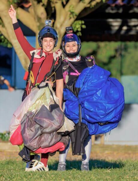 artina smiling and celebrating with a fellow pilot after a jump.