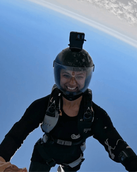 Leah grrining head down during skydive